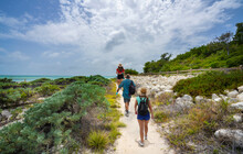 Family Walking To The Beach With Sand Dunes. People Hiking On Beautiful Florida Beach. Bahia Honda State Park, Florida Keys, FLorida,USA.