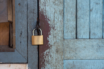 Old master key is lock on the wooden door of the old house.