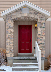 Canvas Print - Vertical Facade of home with stairs on the gabled entrance with vivid red front door