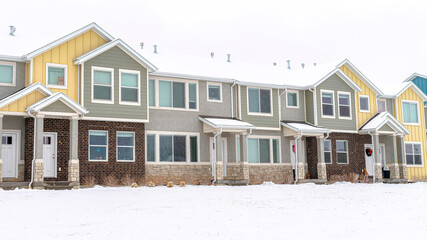 Wall Mural - Pano Apartment houses in a snowy neighborhood with cloudy sky background in winter