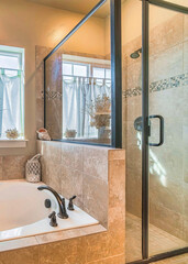 Wall Mural - Vertical Bathtub and shower stall of warm toned bathroom with tiled wall and floor