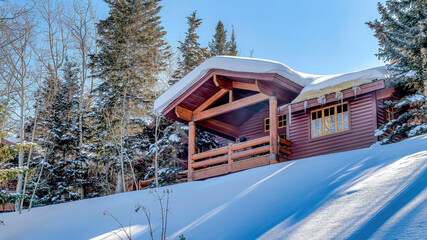 Wall Mural - Pano Facade of mountain home with brown wood wall and balcony against blue sky