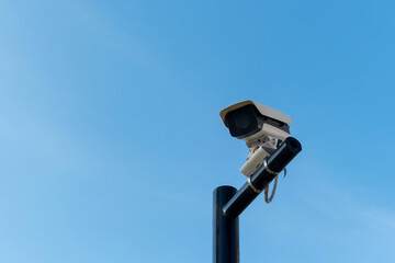 CCTV security cameras on a large post, taken on a sunny bright day with blue sky