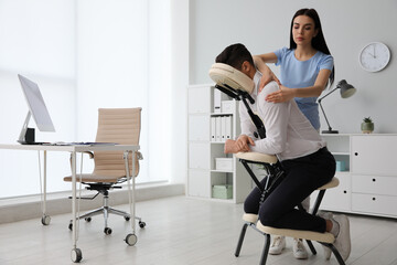 Canvas Print - Man receiving massage in modern chair indoors