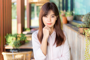 Happy young attractive asian business woman smiling at camera, standing at outdoor patio of her office, happy modern lifestyle