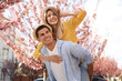 © New Africa - Happy stylish couple near blossoming sakura tree on city street. Spring family look