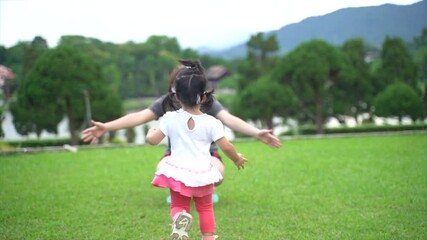 Wall Mural - cute baby running to her mother in the garden, family happy concept