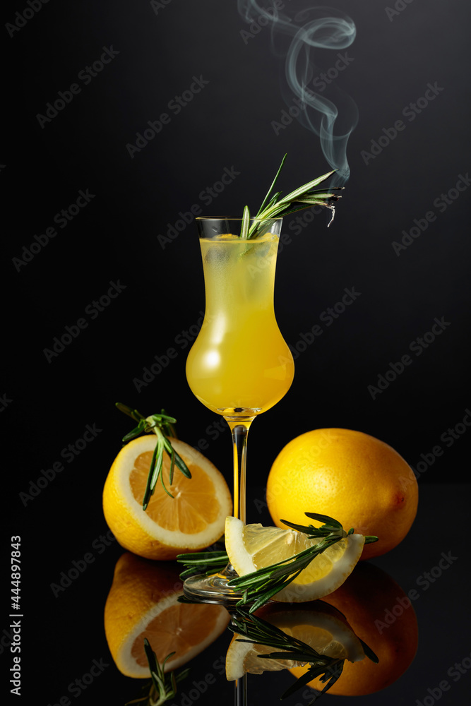 Traditional homemade lemon liqueur limoncello on the black background. - obrazy, fototapety, plakaty 