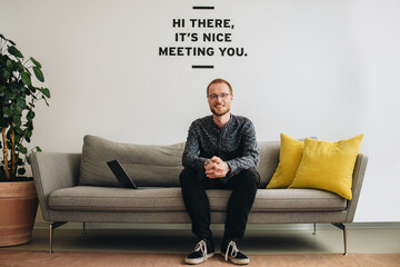 Wall Mural - Confident entrepreneur sitting in lobby