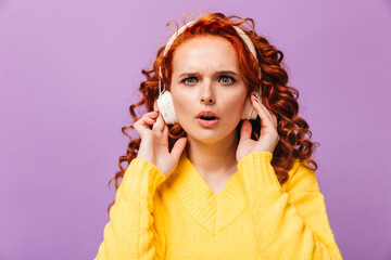 Sticker - Woman in yellow sweater and headphones looks suspiciously into camera