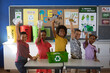 © Wavebreak Media - Portrait of group of diverse students smiling while holding recyclable plastic items at school