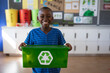 © Wavebreak Media - Portrait of african american boy holding tray filled with recyclable plastic items at school