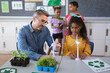 © Wavebreak Media - Caucasian male teacher holding windmill model teaching a girl during environment class at school
