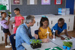 © Wavebreak Media - Caucasian male teacher holding windmill model teaching boy and girl in environment class at school