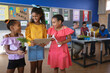 © Wavebreak Media - Three african american girls smiling looking at each other in environment class at school