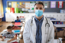 Portrait Of Caucasian Male Doctor Wearing Face Mask Standing In The Class At School