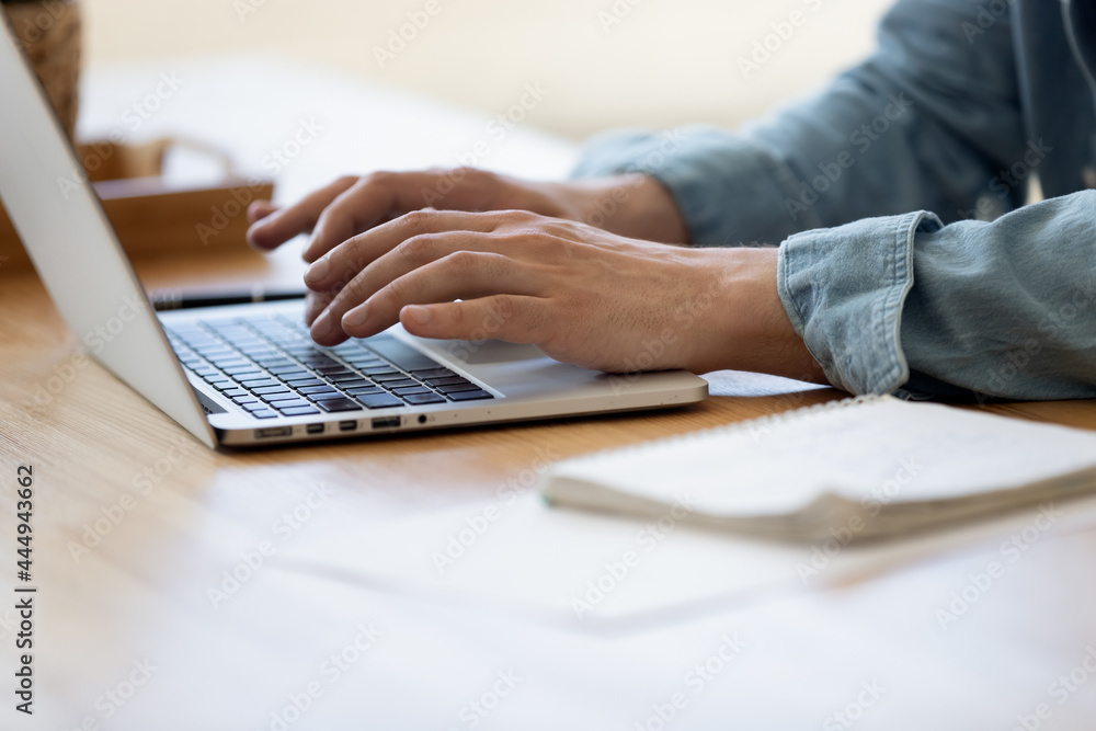 Close up view male hands writes on laptop. Entrepreneur man sit at desk work on modern wireless notebook, do remote telecommute, search information on internet, professional application usage concept - obrazy, fototapety, plakaty 