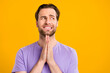 Photo of doubtful stressed gentleman wear violet t-shirt arms together biting lip looking empty space isolated yellow color background