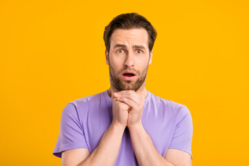 Poster - Photo of scared worried guy pleading face hold hands wear violet t-shirt isolated yellow color background