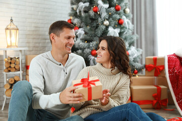 Canvas Print - Man presenting Christmas gift to his girlfriend at home