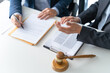 © Charlie's - Legal counsel presents to the client a signed contract with gavel and legal law. justice and lawyer concept