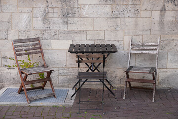 Wooden chairs around a wooden table in an outdoor cafe