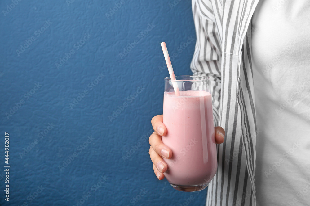 Woman with glass of tasty smoothie on blue background, closeup. Space for text - obrazy, fototapety, plakaty 