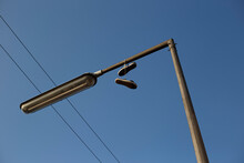 Abandoned Shoes On A Street Lamp
