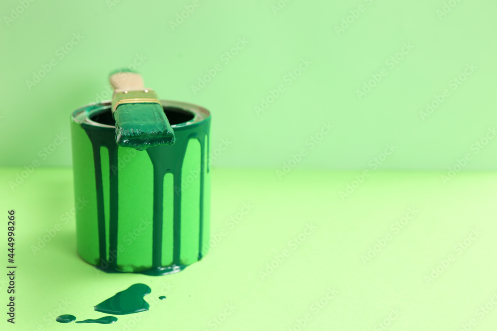 Can of green paint with brush on color background. Space for text - obrazy, fototapety, plakaty 