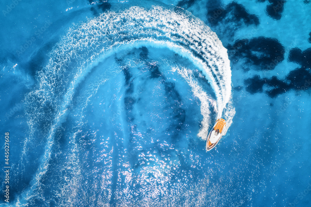 Aerial view of the speed boat in clear blue water at sunny day in summer. Top view from drone of fast floating yacht in mediterranean sea. Travel in Oludeniz, Turkey. Tropical landscape with motorboat - obrazy, fototapety, plakaty 