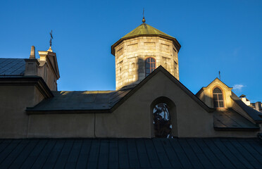 Wall Mural - Domes and facade with christian cross on the tower of Ancient Armenian church of the Assumption of Mary in Lviv, Ukraine