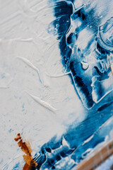 Sticker - Vertical closeup image of a textured white wall with blue, brown, and white paint splashes on it