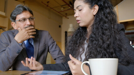 Poster - South Asian young woman and South Asian man from India during a discussion at work