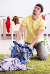 Wall Mural - Handsome man husband doing laundering at home