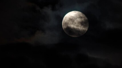 clouds drifting across the sky. full moon in the background