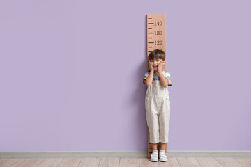 Wall Mural - Little boy measuring height near color wall