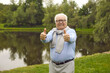 © Studio Romantic - Happy European senior citizen doing like gesture. Cheerful white haired retired old Caucasian man in glasses and shirt standing in green summer park, giving thumbs up, smiling and looking at camera