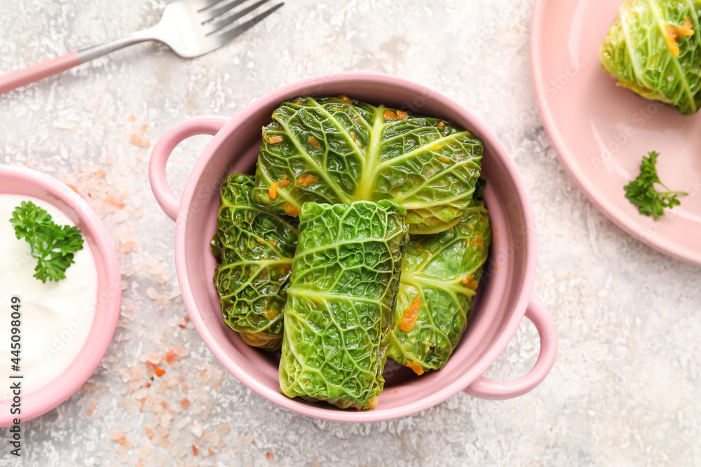 Cooking pot with stuffed cabbage leaves on grunge background
