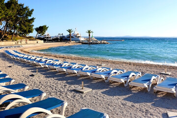 Wall Mural - Deck chairs arranged on a beautiful beach near Split, Croatia. Selective focus.