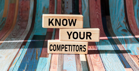 Wall Mural - on wooden blocks the text know your competitors concept of business success.