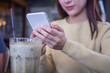 Beautiful freelance woman use of mobile phone to play game and socialize in cafes.