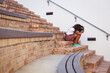 © WavebreakMediaMicro - Unhappy african american schoolgirl sitting on steps in school yard with schoolbag