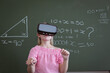 © WavebreakMediaMicro - Caucasian schoolgirl standing at chalkboard in classroom wearing vr headset