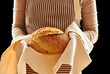 Baker holding loaf of homemade bread