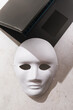Top view of white cardboard mask and laptop, internet anonymity concept
