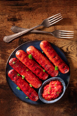 Wall Mural - Grilled sausages, shot from the top on a dark rustic wooden table. Frankfurter bratwurst, sausage of beef and pork meat