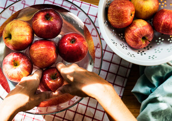 Wall Mural - Aerial view of hands washing apples in bowl