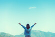 © tonktiti - Copy space of woman rise hand up on top of mountain and sunset sky abstract background.