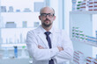 © Qwenergy - Pharmacist is working. Man wearing special medical uniform located in pharmacy.