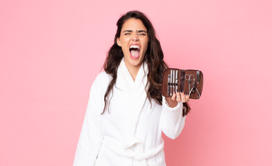 Wall Mural - pretty woman shouting aggressively, looking very angry and holding a making up bag with nails tools